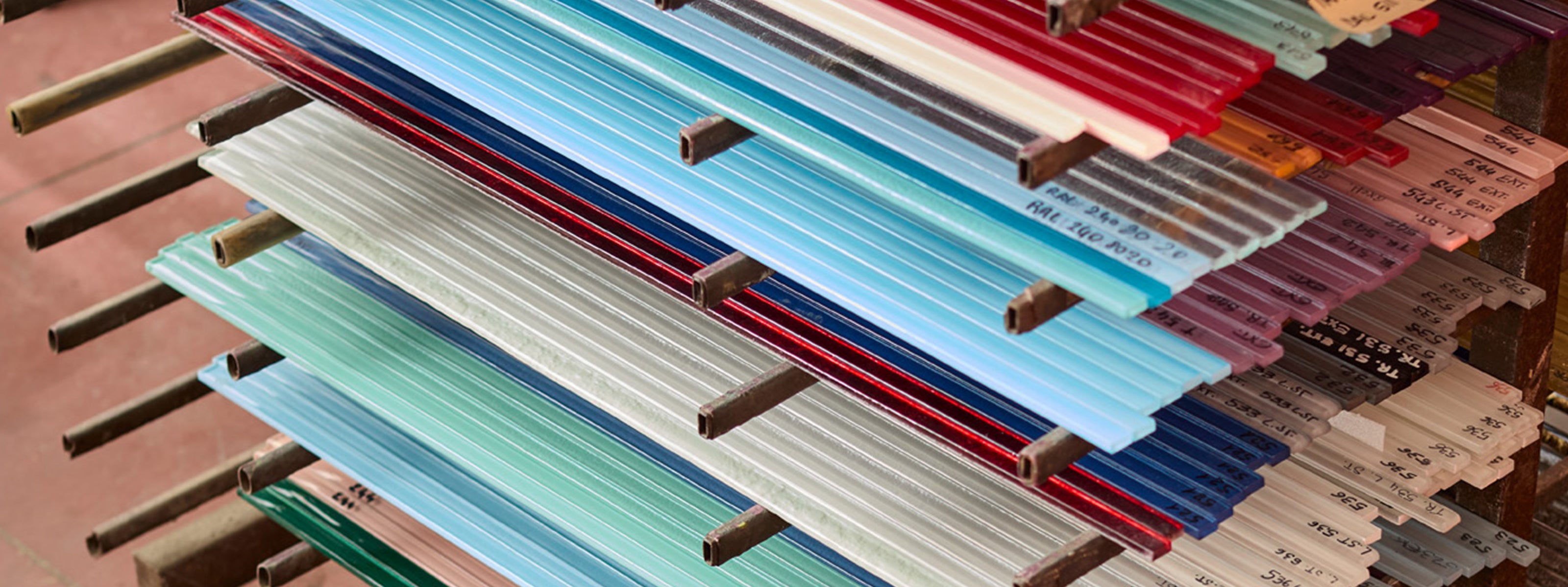 Stack of colorful glass sheets on a wooden surface